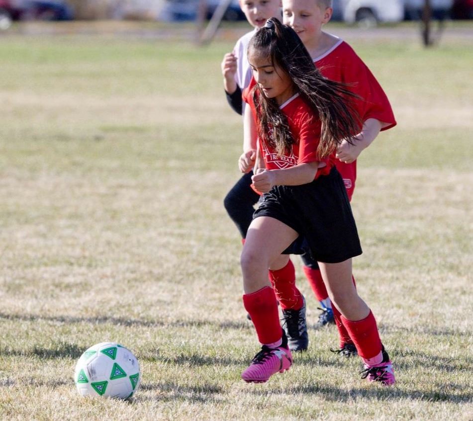 A girl kicking a soccer ball