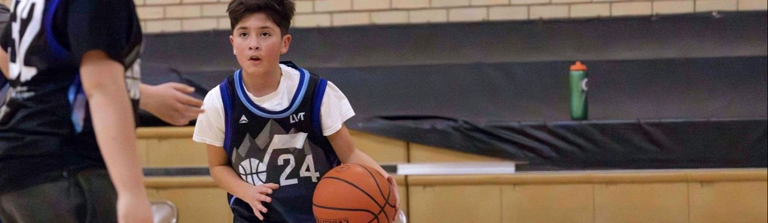 a boy dribbling a basketball